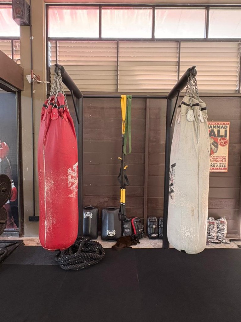 Two Muay Thai heavy bags with battle rope and holder pads at Bambu