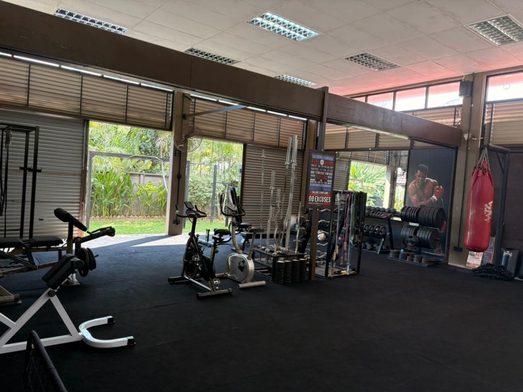 Open-bay gym at Bambu with free weights, spin bikes and Muhammad Ali mural
